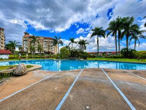 a swimming pool at a resort with palm trees at Graceland Resort Tayabas Quezon in Tayabas