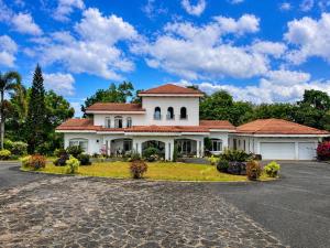 a large white house with a driveway at Graceland Resort Tayabas Quezon in Tayabas