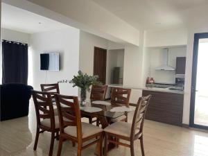 a dining room and kitchen with a table and chairs at Departamento Torre el Morado MAS EXPERIENCIA A CABALLO in La Concepción