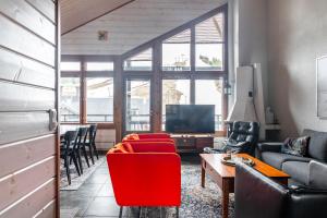 a living room with a couch and chairs and a tv at Himos Mökki superior - Chalet Cottage superior ski-in-ski-out in Jämsä
