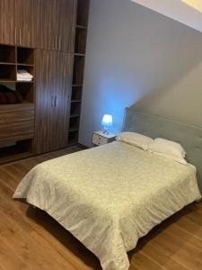 a bedroom with a large bed and a night stand at Departamento Torre el Morado MAS EXPERIENCIA A CABALLO in La Concepción