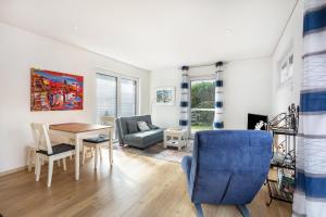a living room with a table and a blue chair at Ferienwohnung Am Hochrhein in Murg