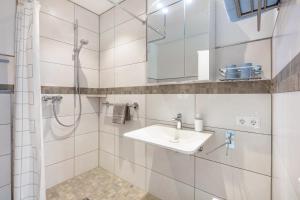 a white bathroom with a shower and a sink at Ferienwohnung Am Hochrhein in Murg +13 photos