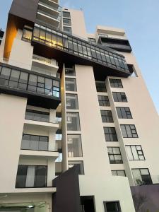 a tall white building with a lot of windows at Departamento Torre el Morado MAS EXPERIENCIA A CABALLO in La Concepción