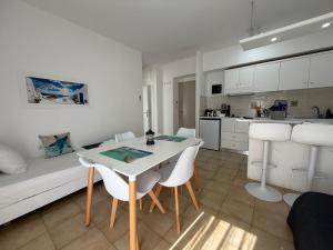 a white living room with a table and chairs at Nautilus City Studios & Apartments in Rhodes Town