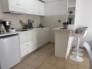 a kitchen with white cabinets and a chair in it at Nautilus City Studios & Apartments in Rhodes Town