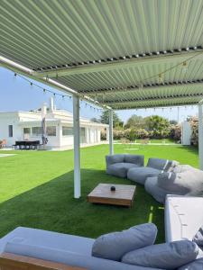 a patio with couches and a table under a canopy at Villa Ikal in Modugno