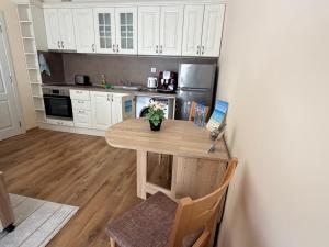 a kitchen with a wooden table and a kitchen with white cabinets at South Beach Apartment at Valencia Gardens in Nesebar +17 photos