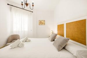 a bedroom with a large white bed and a chair at Costa Africana in Vejer de la Frontera +35 photos