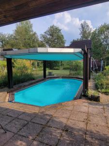 a swimming pool under a pavilion with a swimming poolvisor at Peaceful Vosges heaven in Granges-Aumontzey