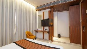 a hotel room with a bed and a television at Hotel Heritage Grand in Thane