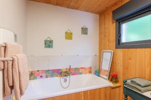 a bathroom with a white tub and a mirror at Casa Frida in Salavas