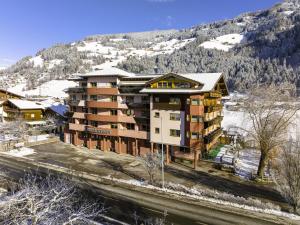 an apartment building with snow on a mountain at Alpenhotel Ramsauerhof in Ramsau im Zillertal