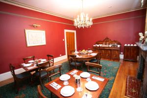 a dining room with red walls and wooden tables and chairs at Darcy's Hotel in Sydney