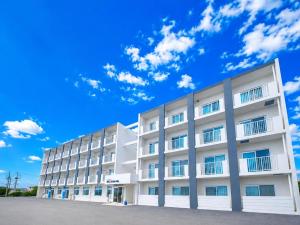 a white building with a blue sky in the background at MrKINJO in Air Resort in Hirara