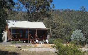 a house in the middle of a forest at The Cabin at Rocklee Grove in Broke