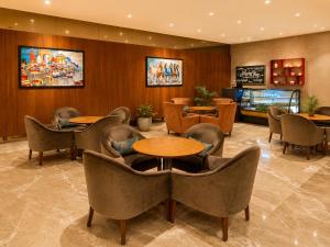 a waiting room with tables and chairs in a hotel at Pride Premier Pune in Pune