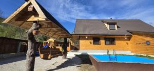 a house with a pool in front of it at Farma pod Skalkou in Heľpa