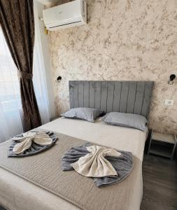 a bedroom with a bed with two towels on it at Ana Boutique in Constanţa
