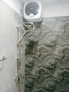 a shower in a bathroom with a wall at Falcon View in Nuwara Eliya
