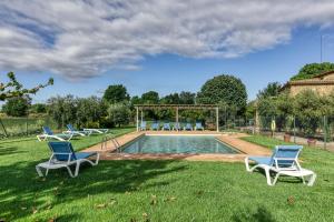 a group of chairs sitting in the grass by a pool at Mas Pareta - La Figuera in Fonolleras