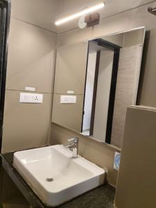a bathroom with a white sink and a mirror at CENTRAL A BOUTIQUE HOTEL in Belgaum +29 photos
