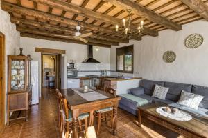 a kitchen and living room with a couch and a table at Mas Pareta - La Figuera in Fonolleras
