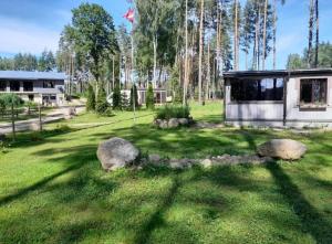 a house in a yard with rocks in the grass at Dreamcatcher in Straupe