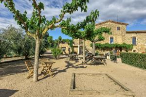 a courtyard with tables and chairs in front of a building at Mas Pareta - La Figuera in Fonolleras