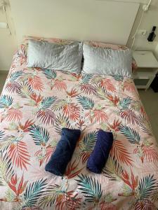 a bed with two blue pillows on it at ÁTICO HOME y Garaje, Algemesi Home in Algemesí