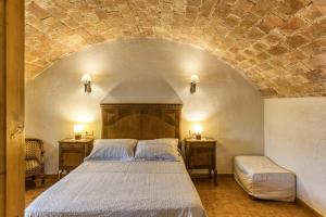 a bedroom with a bed and two tables with lamps at Mas Pareta - La Figuera in Fonolleras +20 photos