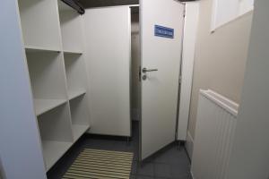 a walk in closet with white shelves and a door at Haus Norderhoog Wohnung 53 in Westerland +22 photos