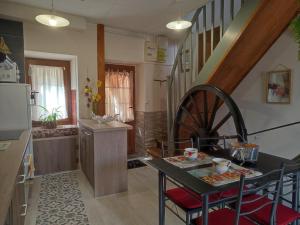 a kitchen and dining room with a table and a wheel at Al clouc in CampÃ´me