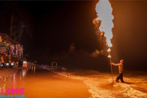 a man standing on a beach holding a pole at LOVE beach club Koh Samui in Chaweng