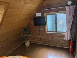 a room with a tv and a window in a cabin at のんびれっじ つくし棟 in Anazawa +11 photos
