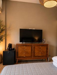 a flat screen tv sitting on top of a wooden entertainment center at Armonium Airport in Ezeiza