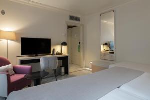 a hotel room with a bed and a desk with a television at Vincci Albayzin in Granada
