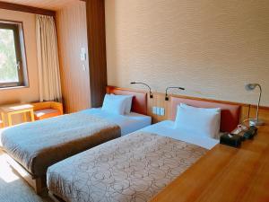 a hotel room with two beds and a window at HOTEL RELIEF Sapporo Susukino in Sapporo