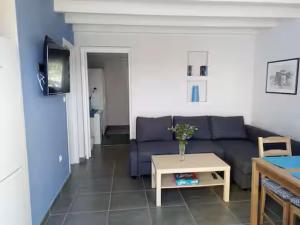 a living room with a blue couch and a table at Corfu Green Escape in Achílleion +9 photos