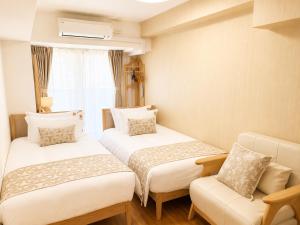 a room with two beds and a couch and a window at Landmark Sunshine Hotel in Osaka +24 photos