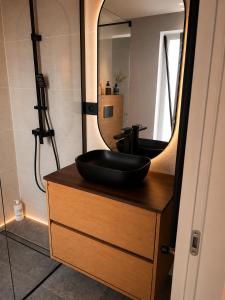 a bathroom with a sink and a mirror on a dresser at Da Vinci Luxury Home Otopeni in Otopeni