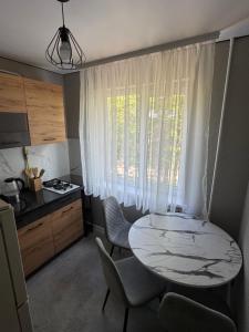 a kitchen with a table and chairs and a window at Premium 2-Room Rental in Bălţi