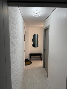a hallway with a white brick wall and a television at Premium 2-Room Rental in Bălţi +1 photo