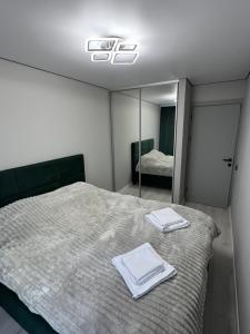 a bedroom with a bed with two towels on it at Premium 2-Room Rental in Bălţi