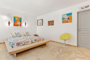 a bedroom with a bed and paintings on the wall at Chambres D’hôte Cotignac in Cotignac +30 photos