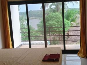 a view of a bedroom with a large window at Hiran Holidays in Sasan Gir