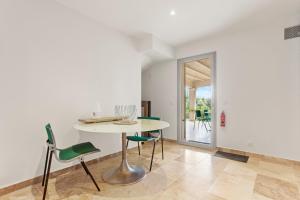 a dining room with a white table and green chairs at Chambres D’hôte Cotignac in Cotignac