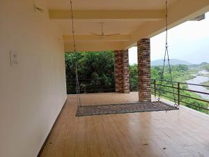 an empty house with a porch with a swing at Hiran Holidays in Sasan Gir