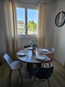 a dining room table with chairs and a large window at L'écrin De Mouroux - Disney 20 min - Clim & Parking in Mouroux