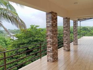 an empty house with a balcony with a view of the forest at Hiran Holidays in Sasan Gir
